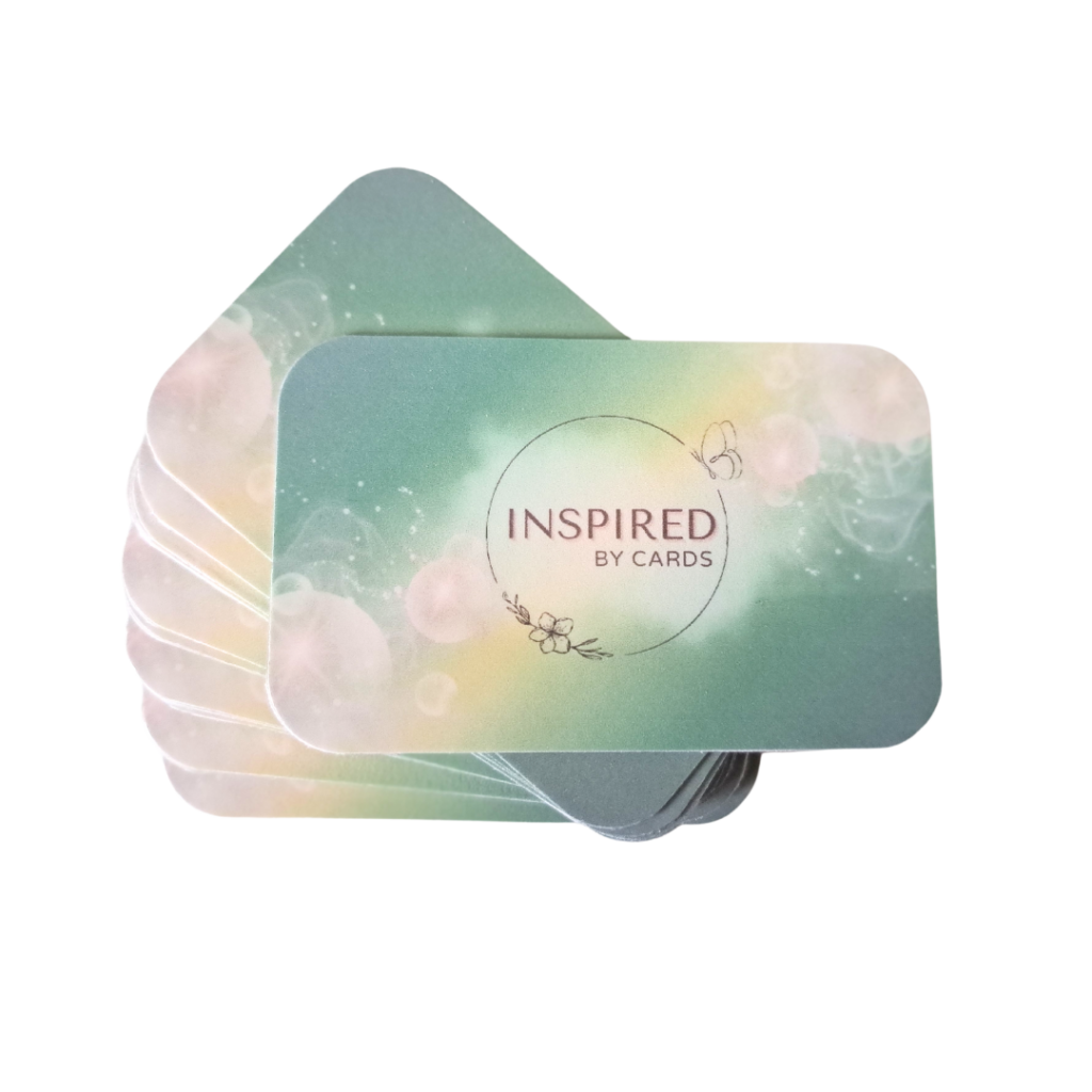 Een stapel affirmatiekaarten van More2Inspire. De affirmatiekaartjes hebben afgeronde hoeken en een achtergrond kleurverloop van groen. Op de voorste affirmatiekaart staat de tekst Inspired by Cards.