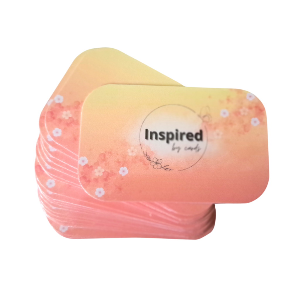 Een set affirmatiekaarten van More2Inspire met een oranje kleurverloop en geel. De tekst Inspired by Cards staat op de voorkant van de bovenste affirmatiekaart.
