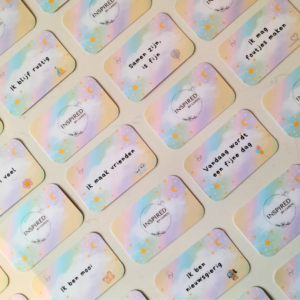 Set affirmatiekaarten voor kinderen met pastelkleuren en sterren. De kaarten met positieve teksten bevatten vrolijke afbeeldingen, naast de affirmaties. De affirmatiekaartjes zijn in een raster neergelegd.